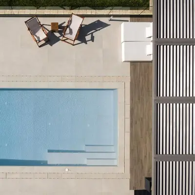 two chairs and a swimming pool on a building at Artemis Villa, Beachfront Retreat with Heated Pool, By ThinkVilla in Tavronitis