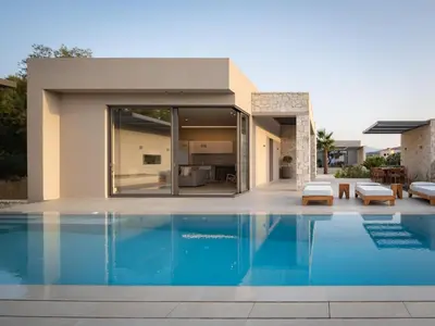 a swimming pool in front of a house at Artemis Villa, Beachfront Retreat with Heated Pool, By ThinkVilla in Tavronitis