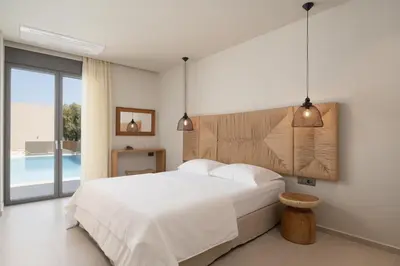 a bedroom with a bed and a swimming pool at Amalthia Villa, Heated Pool & Walk to the Beach, By ThinkVilla in Tavronitis