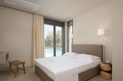 a bedroom with a bed and a large window at Amalthia Villa, Heated Pool & Walk to the Beach, By ThinkVilla in Tavronitis