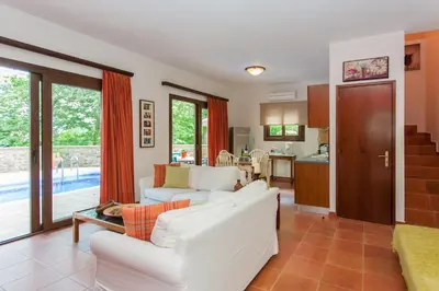 a living room with two white couches and a kitchen at Arhontika Villas in Élos