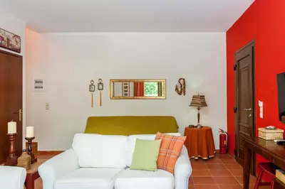 a living room with a white couch and a red wall at Arhontika Villas in Élos