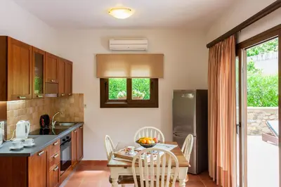 a kitchen with a table and chairs and a dining room at Arhontika Villas in Élos