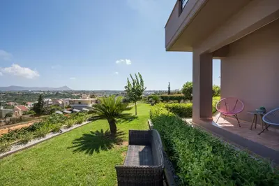 a balcony with a bench and a view of a yard at Tholos Apartments in Chania Town