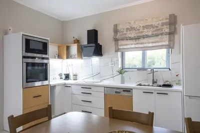 a kitchen with white appliances and a wooden table at Sofia's seaview house in Plataniás