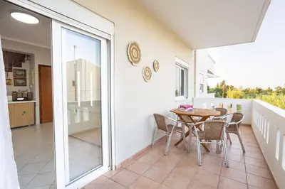 a balcony with a table and chairs in a house at Sofia's seaview house in Plataniás