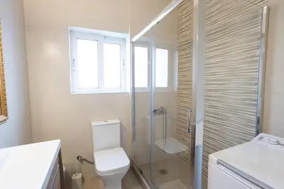 a bathroom with a toilet and a glass shower at Sofia's seaview house in Plataniás