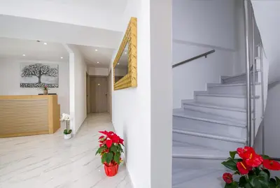a staircase in a house with red flowers at Deluxe City Hotel in Chania Town