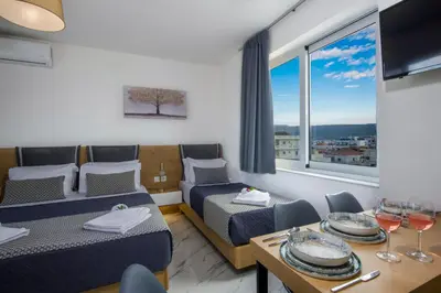 a room with two beds and a table with wine glasses at Deluxe City Hotel in Chania Town