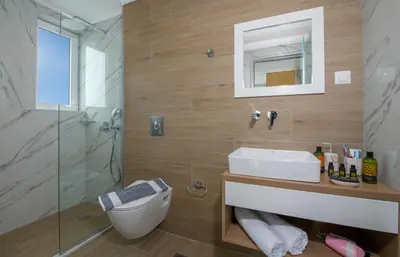 a bathroom with a toilet and a sink and a shower at Deluxe City Hotel in Chania Town