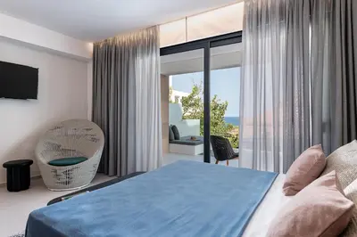 a bedroom with a blue bed and a balcony at Nuovo Luxury Suites in Daratso