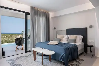 a bedroom with a bed and a balcony with a view at Nuovo Luxury Suites in Daratso