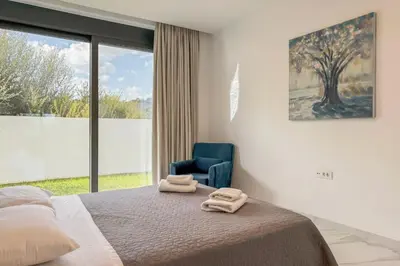 a bedroom with a bed and a blue chair at Villa Valentina Chania in Kalathas