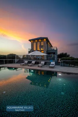a villa with a swimming pool at sunset at Seacrete villas in Chania Town
