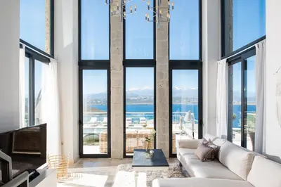 a living room with a couch and large windows at Seacrete villas in Chania Town