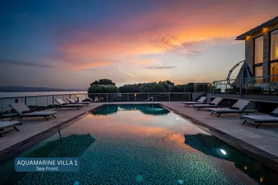 a pool on the roof of a building with a sunset at Seacrete villas in Chania Town