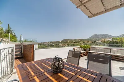 a wooden table with a vase on top of a balcony at Villa Eftychia - villa with 2 private pools!!! by PosarelliVillas in Almirida