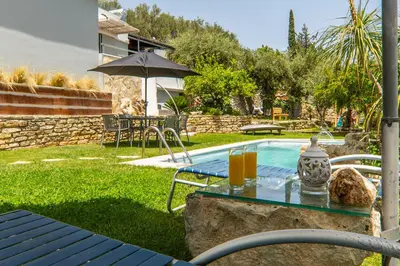 a table with drinks on it next to a swimming pool at Villa Eftychia - villa with 2 private pools!!! by PosarelliVillas in Almirida