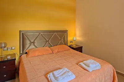 a bedroom with a large bed with two towels on it at Cabanavillas MILANO by PosarelliVillas in Agia Marina Nea Kydonias