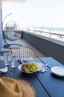 a blue table with a plate of grapes on it at Phaedra's Studios in Kolymbari in Chania Town