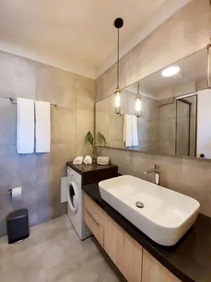 a bathroom with a sink and a washing machine at Phaedra's Studios in Kolymbari in Chania Town