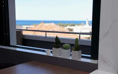 a window with cactuses on a ledge with a view at Phaedra's Studios in Kolymbari in Chania Town