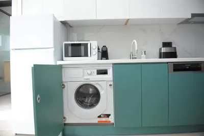 a kitchen with a washing machine and a microwave at Phaedra's Studios in Kolymbari in Chania Town
