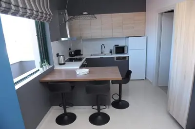 a kitchen with a wooden table and two bar stools at Phaedra's Studios in Kolymbari in Chania Town