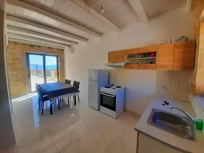 a small kitchen with a table and a stove at Mitato Stylianos in Kounoupítsa
