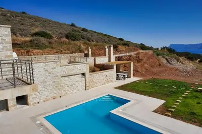 a villa with a swimming pool on a hill at Bangalows Stylianos in Kounoupítsa