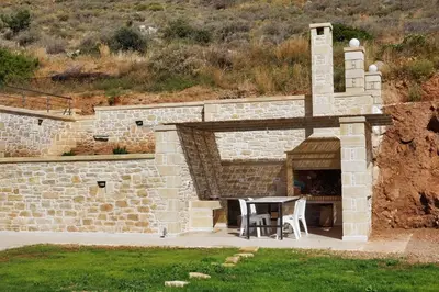 a brick oven with a table and chairs in it at Vilitsa Stylianos in Kounoupítsa
