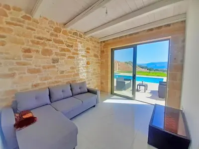 a living room with a couch and a pool at Vilitsa Stylianos in Kounoupítsa