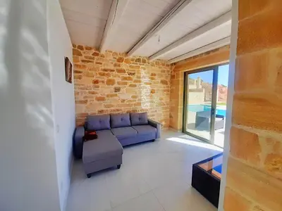 a living room with a blue couch and a brick wall at Vilitsa Stylianos in Kounoupítsa