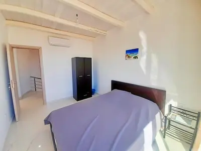 a bedroom with a bed with a blue blanket on it at Vilitsa Stylianos in Kounoupítsa