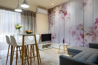 a living room with a table and a tv at Casa Gardenia-modern apartment next to the beach, near Old Town in Chania Town