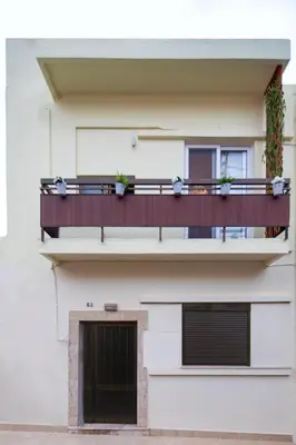 a building with a balcony with two plants on it at Casa Gardenia-modern apartment next to the beach, near Old Town in Chania Town