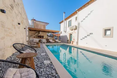 a swimming pool with chairs next to a building at Villa Kirke in Próvarma