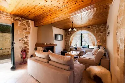 a living room with couches and a stone wall at Villa Kirke in Próvarma