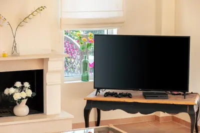 a flat screen tv sitting on a table next to a fireplace at Lake and Sea Villa in Tersanas