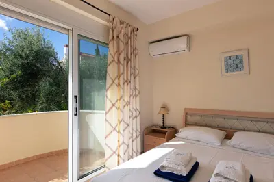 a bedroom with a bed and a large window at Lake and Sea Villa in Tersanas