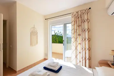 a bedroom with a bed and a sliding glass door at Lake and Sea Villa in Tersanas