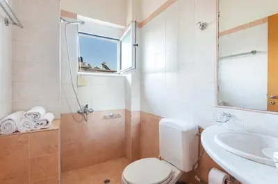 a bathroom with a toilet and a sink and a shower at Anna Αpartments II in Agia Marina Nea Kydonias