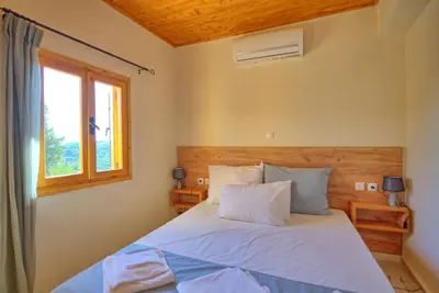 a bedroom with a bed and a window at Villa Vicilla by PosarelliVillas in Fílippos