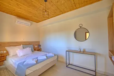 a bedroom with a bed and a mirror at Villa Vicilla by PosarelliVillas in Fílippos