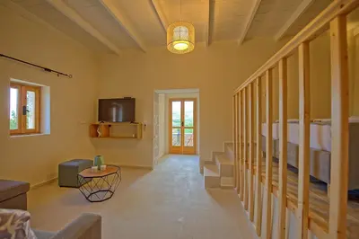 a living room with a staircase and a tv at Villa Vicilla by PosarelliVillas in Fílippos