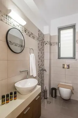 a bathroom with a sink and a mirror and a toilet at Park View and near the Sea Villa with Private Pool 1 in Chania Town
