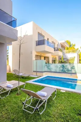 a villa with a swimming pool and two lawn chairs at Park View and near the Sea Villa with Private Pool 1 in Chania Town