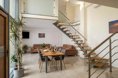 a staircase in a living room with a table and chairs at Park View and near the Sea Villa with Private Pool 1 in Chania Town