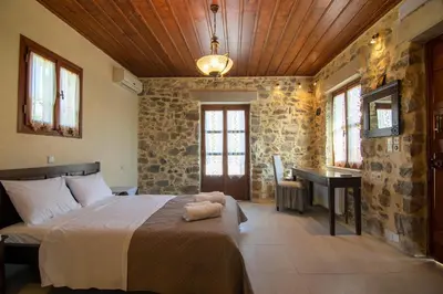 a bedroom with a bed and a desk in a room at Archodiko Villa Imbros in Ímbros