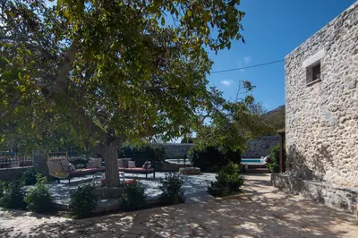 a courtyard with a tree and a stone wall at Archodiko Villa Imbros in Ímbros
